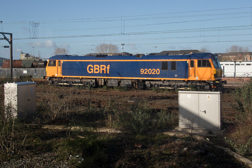 92020, stabled, Crewe South 
 I think that the GBRf livery really suits the class 92s with their large slab sides. It is remarkably similar to BR's large logo livery that was applied to many locomotives on the 1980s and 1990s. With its pantograph down, 92020 appears to be stabled in Crewe South yard. Notice the hulk of boiler behind the AC electric undergoing restoration. 
 Keywords: 92020 Crewe South