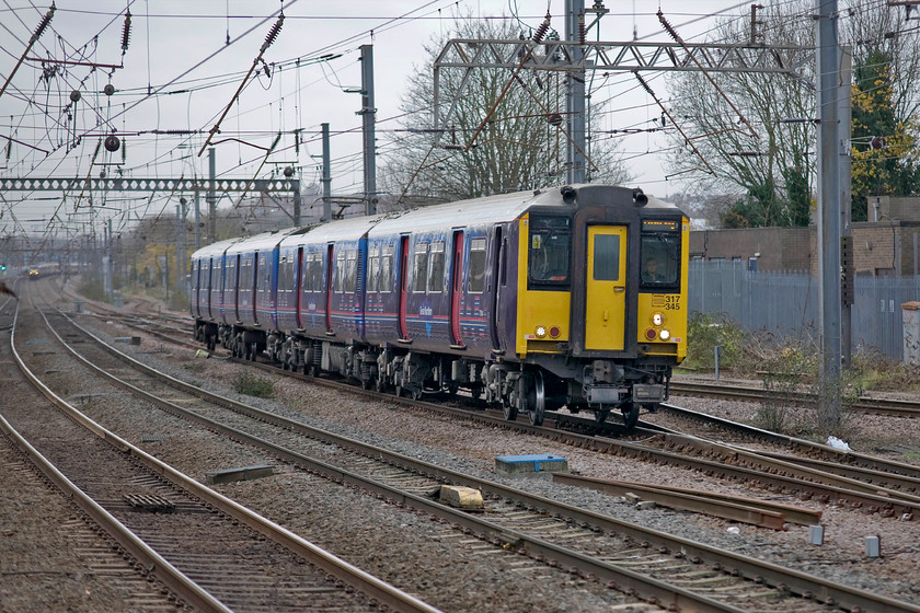 317345, GN 08.56 London King's Cross-Hertford North (2B14), Alexandra Palace station 
 Great Northern's 317245 slows for its stop at Alexandra Palace station forming the 2B14 08.56 King's Cross to Hertford North. On leaving the station the unit will keep to the far left down line and then cross the ECML on a large flyover built to avoid conflicting moves that would slow rest of the lines on this intesivly used seaction of the network. 
 Keywords: 317345 08.56 London King's Cross-Hertford North 2B14 Alexandra Palace station Great Northern