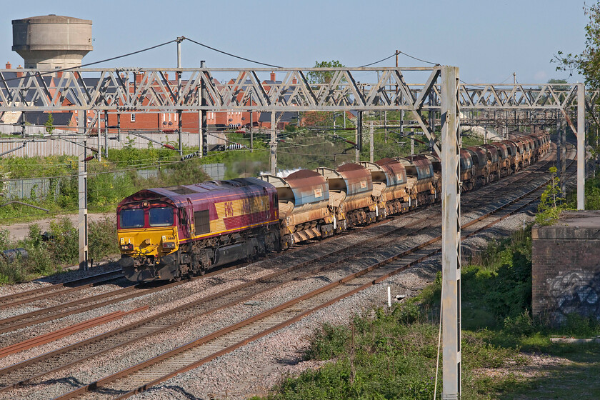 66161, 16.26 Watford South Junction-Bescot (6R01, 18E), site of Road station 
 A very faded 66161 approaches Roade near to the site of the village's former station leading the 16.26 Watford to Bescot 6R01 engineering train. The stock is composed of a rake of HQA autoballsters that were involved in work on the fast lines in the Watford area. After the awful weather of the previous few weeks, making May one of the wettest and coolest on record, it's nice to get such a smashing late afternoon with lovely lighting. 
 Keywords: 66161 16.26 Watford South Junction-Bescot 6R01 site of Road station EWS DB