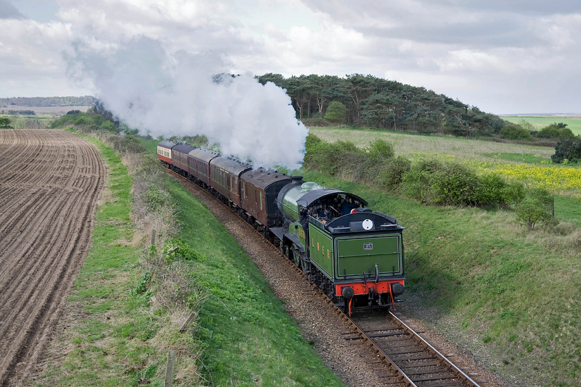 8572, 12.00 Holt-Sheringham, Dead Man's Hill 
 Former LNER B12 number 8572 runs tender first leading the 12.00 Holt to Sheringham North Norfolk Railway service. The train is seen approaching a small bridge that carries a footpath over the railway at the delightfully named Dead Man's Hill. 
 Keywords: 8572 12.00 Holt-Sheringham Dead Man's Hill Poppy Line NNR North Norfolk Railway LNER B12 4-6-0