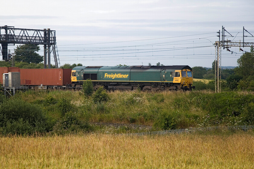 66537, 03.15 Felixstowe North-Trafford Park (4M69, 2E), between Roade & Ashton 
 With some weak sunshine just illuminating the flanks of the train, 66537 leads the 03.15 Felixstowe to Trafford Park Freightliner between the Northamptonshire villages of Roade and Ashton. This shot is better during the winter as the lineside growth in the summer just begins to encroach a little half hiding the bogies. 
 Keywords: 66537 03.15 Felixstowe North-Trafford Park 4M69 between Roade & Ashton