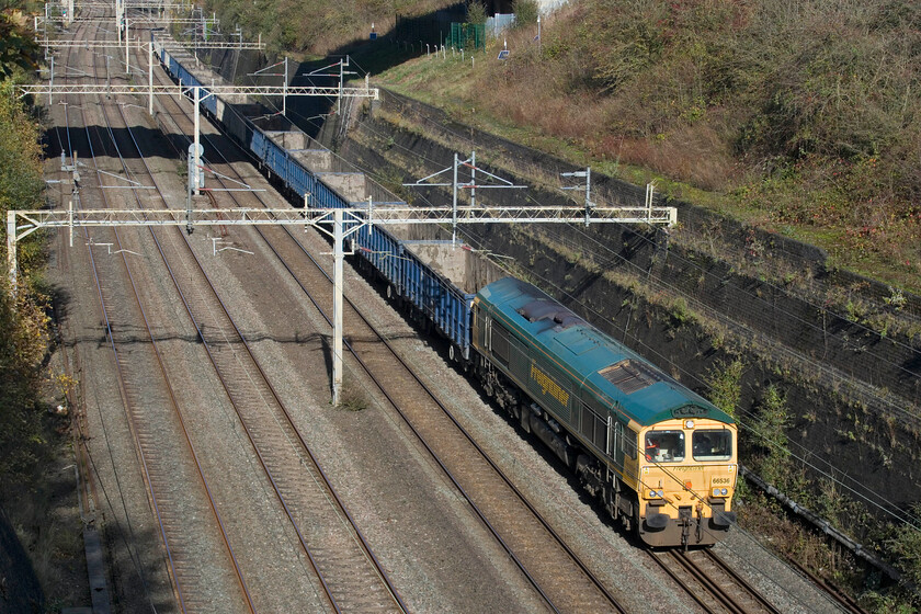 66536, 10.59 New Bilton-Willesden Euroterminal (6R98, 17E), Roade cutting 
 Another empty, well almost at least, 6R98 train heads through Roade cutting having deposited spoil at New Bilton near Rugby. 66536 is leading the train that had just past a loaded train heading in the other direction taking yet more spoil from HS2 works for disposal in a huge and now flooded former quarry. Interestingly, the rear five wagons are returning south fully loaded something that is often seen when this train passes. 
 Keywords: 66536 10.59 New Bilton-Willesden Euroterminal 6R98 Roade cutting