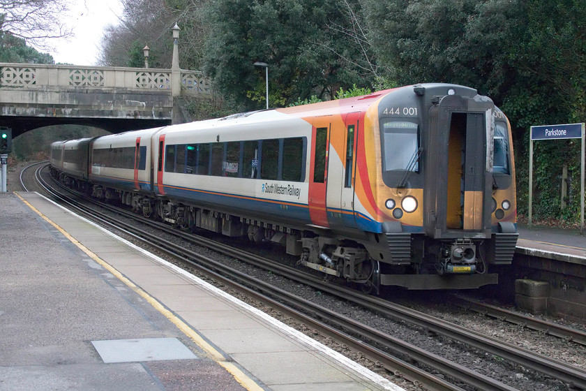 444001, SW 11.35 London Waterloo-Weymouth (1W23, 4L), Parkstone station 
 With its interconnecting door open, of which I suspect there would be some draft issues for the driver and the passengers in the first coach, 444001 arrives at Parkstone station with the 11.35 Waterloo to Weymouth train. The station is located about halfway up the fearsome Parkstone bank. The ascent commences almost immediately after leaving Poole station climbing at a steady 1:60 before levelling out through Parkstone station. As can be seen towards the rear of this train, it then climbs again at 1:60 to the summit at Branksome. Today, electrics would hardly even notice the climb but in steam days the drivers of the Somerset and Dorset and the London and South Western would have had to work their locomotives hard when heading east towards Bournemouth especially if making a standing start from Poole station. 
 Keywords: 444001 11.35 London Waterloo-Weymouth 1W23 Parkstone station South Western Trains SWR