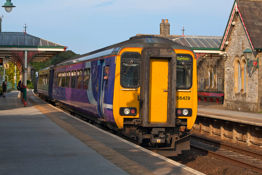 156429, NT 14.41 Carlisle-Lancaster (2C58), Grange-over-Sands station 
 By the time Andy and I had come out of The Lakes and reached the south Cumbrian Coast the sun had come back out again. In absolutely superb light, 156429 arrives at Grange-over-Sands station working the very late running 14.41 Carlisle to Lancaster. The guard peers out of the rear cab, no doubt wondering if there will be more complaints aimed at him because of the continuation of Northern's terrible handling of their 'timetable changes' that caused such chaos over the last few months. Grange-over-Sands is a superb station in a stunning spot with the estuary of Morecambe Bay stretching out to the back of it. 
 Keywords: 156429 2C58 Grange-over-Sands station