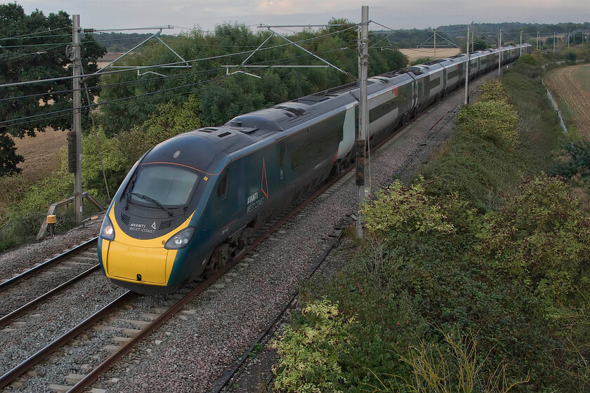 390155, VT 17.39 London Euston-Glasgow Central (9S96, 7L), Blisworth 
 350155 'Railway Benefit Fund' sweeps around the first of a number of reverse curves on the Weedon 'old line' as it passes Blisworth working Avanti's 17.39 Euston to Glasgow Central 9S96. This part of the route will test the Pendolino's tilting capabilities and the skills of the permanent way teams who maintain the track ensuring that passengers can drink their latts without spillage! 
 Keywords: 390155 17.39 London Euston-Glasgow Central 9S96 Blisworth Avanti west coast Railway Benefit Fund