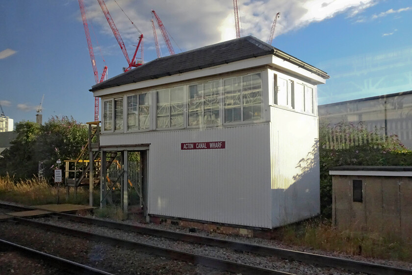 Acton Canal Wharf signal box (NR, 2004) 
 Acton Canal Wharf signal box is totally unrecognisable from the box that I photographed (and visited) on a cold and bright day in November 1979, see.... https://www.ontheupfast.com/p/21936chg/27444280004/acton-canal-wharf-signal-box-tq211829 Whilst the brick base is just visible below the UPVC cladding the old Midland box dating from 1894 is all but gone with Network Rail encasing the old structure and then removing it from within. In a nod to the old structure, it appears that the original Midland wooden nameboard has been retained. 
 Keywords: Acton Canal Wharf signal box