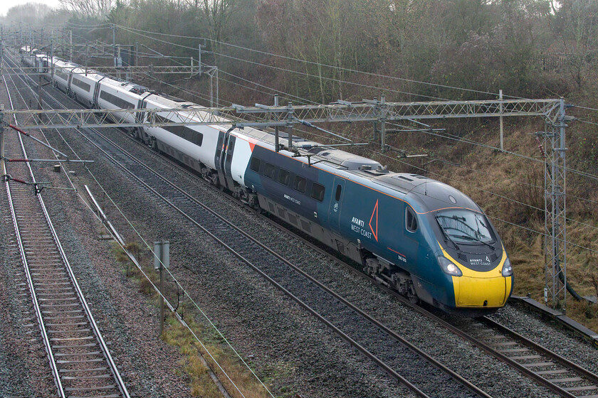 390010, VT 10.43 London Euston-Preston (diverted via Trent Valley) (5S60, 7E), Victoria bridge 
 390010 'Cumbrian Spirit' works the 10.43 Euston to Preston carrying curious reporting number of 5S60. Unfortunately, things did not go to plan with this service later in its journey with it taking the Trent Valley route rather than the advertised route via Birmingham New Street. I suspect that the cause of this was staffing issues relating to very high numbers of staff testing positive for the COVID-19 Omicron variant that was impacting all TOCs not just those of Avanti West Coast. The train is seen passing Victoria bridge between Ashton and Roade in South Northamptonshire. 
 Keywords: 390010 10.43 London Euston-Preston diverted via Trent Valley 5S60 Victoria bridge Avanti West Coast Pendolino Cumbrian Spirit