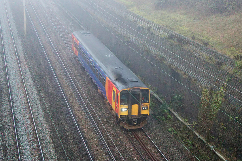 153311, 10.30 Etches Park-Wolverton Centre Sidings (5Z53, 10E), Roade cutting 
 With the fog being so dense getting photographs deep in Roade cutting proved problematic. 153311 approaches journey's end as the 5Z53 10.30 Derby Etches Park to Wolverton. I had been tracking the progress of this train since it left Derby. Having arrived nearly an hour early at Rugby I thought it would simply carry on taking full advantage of the gained time. However, with a booked slot to leave the WCML at Wolverton quite tricky to obtain, it was held at Rugby losing virtually all of its advantage by the time it passed here at Roade.

This is one of the units that was acquired by Network Rail six months after this image was taken to become one of their infrastructure recording trains, see......... https://www.ontheupfast.com/p/21936chg/30020851257/x3-153376-153311-stabled-norwich 
 Keywords: 153311 10.30 Etches Park-Wolverton Centre Sidings 5Z53 Roade cutting East Midlands Trains East Midlands Railway Regional EMR