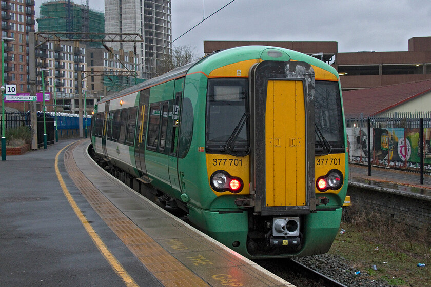 377701, SN 16.51 Watford Junction-East Croydon (2O55, 2E), Watford Junction station 
 I lament the withdrawal of Southern services from Milton Keynes that stopped a few years ago, as we used to use them regularly as an easy alternative way to reach Central London (Kensington Olympia). Now they start from and terminate at Watford Junction using the bay platform ten. The 16.51 to East Croydon is seen worked by Electrostar 377701. Notice the mural in the background that appears to feature a Class 319 in a London Midland livery. 
 Keywords: 377701 16.51 Watford Junction -East Croydon 2O55 Watford Junction station Southern Electrostar