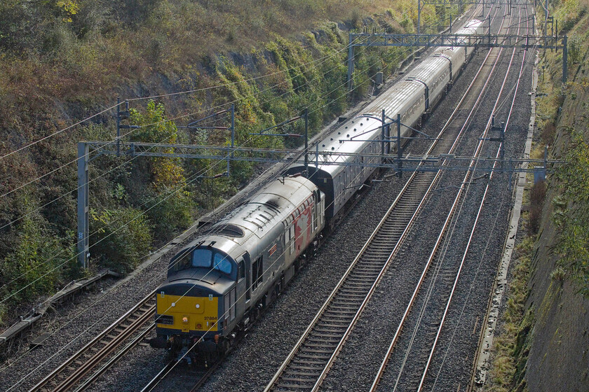 37884, 11.25 Wolverton Centre Sidings-Carlisle (5N09, 68E), Roade cutting 
 37884 'Cepheus' roars through Roade cutting having just left Wolverton Works with the 5N09 11.25 stock move to Carlisle. It is dragging a set of ScotRail Mk. III HST coaches to Scotland following work undertaken at the works. After an overnight sojourn at Carlisle the stock would continue on to Inverness the following day. 
 Keywords: 37884 11.25 Wolverton Centre Sidings-Carlisle 5N09 Roade cutting ROG Rail Operations Group Cepheus