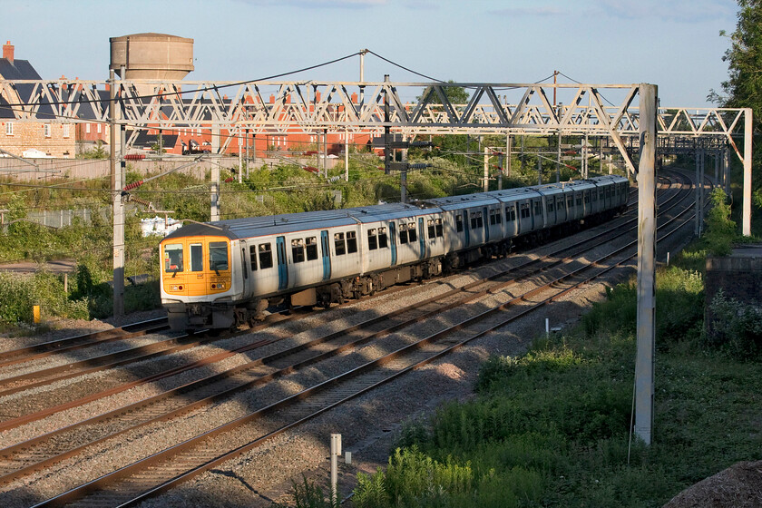 319012, LN 19.35 Milton Keynes-Northampton EMD (5N33, 10E), site of Roade station 
 With the dramatic reduction in peak-time travel following COVID I remain surprised that London Northwestern retain and uses their small operational fleet of former Thameslink Class 319s. However, they do provide a slightly more intertsing alternative to the usual diet of constant Class 350s! Having run from London earlier in the evening 319012 returns to Northampton's King's Heath depot as the empty stock 5N33 19.35 from Milton Keynes. The train is seen passing the site of Roade's former station. 
 Keywords: 319012 19.35 Milton Keynes-Northampton EMD 5N33 site of Roade station London Northwestern