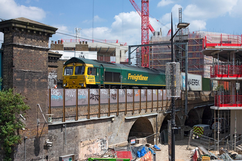 66570, 09.12 Felixstowe North-Ditton (4M63), Camden Viaduct from Camden Market 
 Whilst my wife explored Camden Market's more 'alternative' stalls I waited in one of the shops with a view of the railway. After a short time I was rewarded with 66570 passing over Camden Viaduct with the 09.12 Felixstowe North to Ditton Freightliner. The shop unit's owner had her eye on me, I think that she though I was a jumper as I stood at the open window for so long! The continuous building works here and throughout London staggers me; it's non-stop! 
 Keywords: 66570 09.12 Felixstowe North-Ditton 4M63 Camden Viaduct from Camden Market