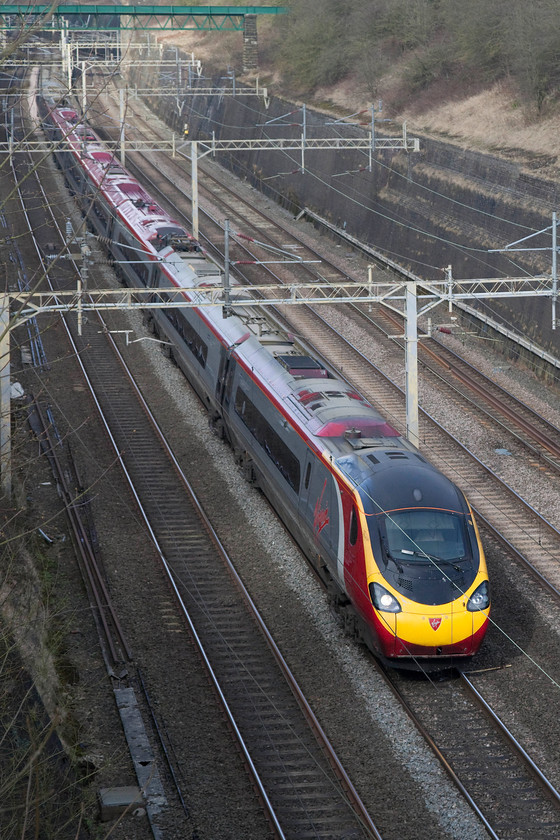 390043, VT 11.07 Wolverhampton-London Euston (1B13, 6E), Roade Cutting 
 390043 'Virgin Explorer' heads south through Road Cutting with the 11.07 Wolverhampton to London Euston. To successfully take a picture of an up train on the fast, a portrait shot is best used as in landscape, the composition is too messy. 
 Keywords: 390043 1B13 Roade Cutting