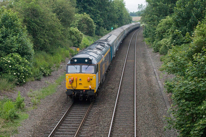 50007, outward leg of The English Riviera Airshow, 06.20 Tame Bridge Parkway-Paignton (1Z50, 23L), King's Sutton SP494358 
 Bringing up the rear of The English Riviera Airshow charter 50007 'Hercules' is seen just south of King's Sutton station. Notice the grey panel below the cab side window. This results from bodywork repairs being carried out by the Class 50 Alliance & The Fifty Fund preservation group in preparation for a full repaint in July. D1015 'Western Champion' is hauling the charter making it a truly Wester Region-themed trip ending up at Paignton. 
 Keywords: 50007 The English Riviera Airshow 06.20 Tame Bridge Parkway-Paignton 1Z50 King's Sutton SP494358 Hercules