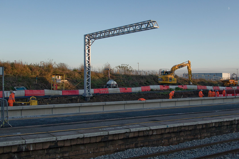 Re-building platform 5, Wellingborough station 
 Work continues at Wellingborough station to reconstruct and reinstate the former platform five that will be numbered four. This will handle 'stopper' services to and from Corby to St. Pancras. I never thought that in my lifetime that I would see such a transformation at Wellingborough with it always having the image of being something of a railway backwater. A lone stanchion stands in the early winter sun yet to be 'fitted up'. Note the first quarter moon high in the late afternoon sky to the top right of the image. 
 Keywords: Re-building platform 5 Wellingborough station elecgtrifiction MML Midland Main line