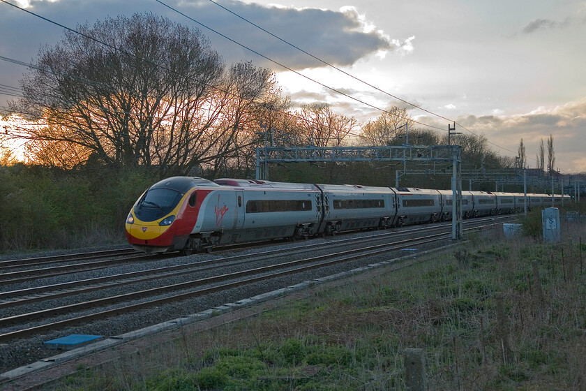 390135, VT 18.15 Manchester Piccadilly-London Euston, Roade 
 Thankfully, the setting sun has dived behind a large cloud making the light a little less tricky! 390135 passes Roade working Virgin's 18.15 Manchester to Euston evening service. 
 Keywords: 390135 18.15 Manchester Piccadilly-London Euston, Roade Virgine West Coast Pendolino