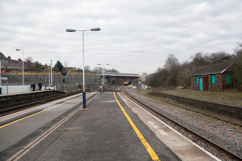 66750, 09.35 Mountsorell-Wellingborough (6F90), Wellingborough station 
 A wide angle view at the north end of Wellingborough station. This view is about to change dramatically as the MML electrification programme takes hold. Notice the recent clearance of the trackbed to the right and the old platform four. The up relief line is is due to be reinstated but I am not sure if the platform is to be reopened but it would make sense given the huge expansion of the town to the east . Notice the remaining Victorian structure on the platform complete with the boarded up windows painted in the old Midland Mainline teal blue, a throwback to when they operated the trains and station some ten years previously. 66750 can be seen in the distance reversing the 6F90 09.35 Mountsorell to Wellingborough stone train back into the sidings. 
 Keywords: 66750 09.35 Mountsorell-Wellingborough 6F90 Wellingborough station