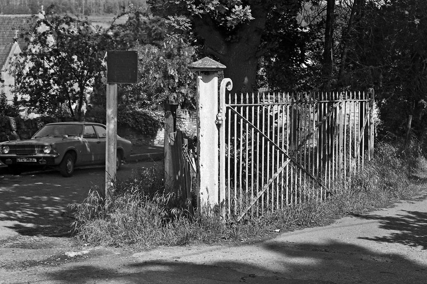 Entrance to former Bathampton station 
 The entrance to the former Bathampton station still has the gate wide open as if it is still in operation! There is also a cast GWR sign still standing next to the gate. Unbelievably, the gate is still there and in the same position today with the entrance road leading down to a couple of houses and some small storage units on the site of the old sidings. Unfortunately, the cast sign is no longer there and I suspect that the 1971/72 Mk. III Ford Cortina parked on Churchill Close is also long-gone; there is no record of it on the DVLA's site. 
 Keywords: Entrance to former Bathampton station