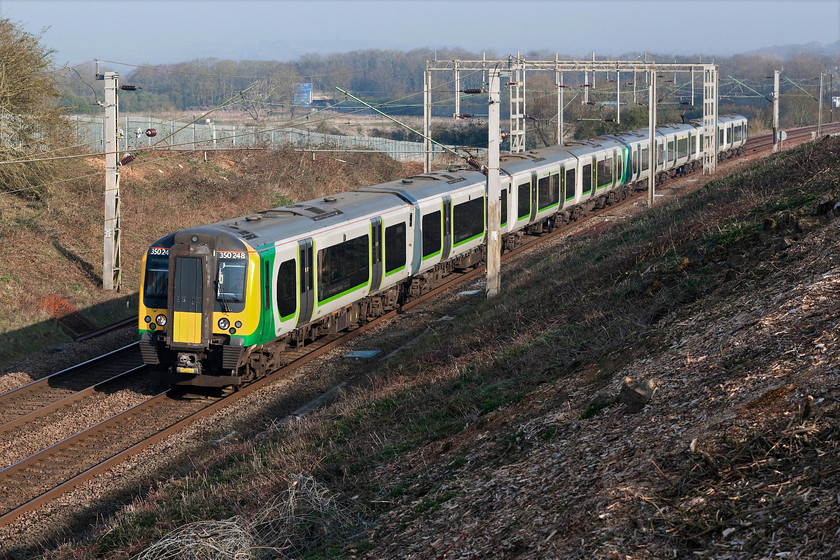 350248 & 350244, LN 06.54 Birmingham New Street-London Euston (2Y52, 1E), Milton Malsor SP738560 
 Thanks to Network Rail's controversial scheme to clear the lineside of excess vegetation and uncontrolled tree growth areas of trackside that were previously off-limits for photography have now been opened up. Here is a great example at Milton Malsor just south of Northampton. 350248 and 350244 pass the wonderfully open spot with the 06.54 Birmingham New Street to Euston. Notice in the background the large sign on the nearby M1 for Junction 15A and Northampton services. 
 Keywords: 350248 350244 06.54 Birmingham New Street-London Euston 2Y52 Milton Malsor SP738560