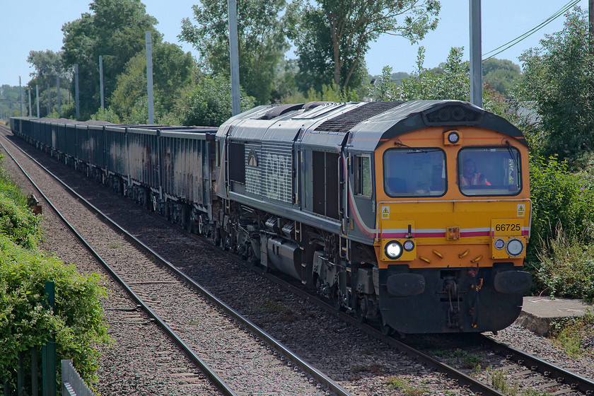 66725, 08.13 Wellingborough-Whatley (6V042), from Colthrop Crossing Box 
 Taken from the open end window of Colthrop Crossing box 66725 'Sunderland' leads the 08.13 Wellingborough to Whatley Quarry stone empties running as 6V42. Behind the train can be seen the march of change heading westwards, the electrification masts have been installed if extremely late and massively over budget! 
 Keywords: 66725 08.13 Wellingborough-Whatley 6V042 from Colthrop Crossing Box