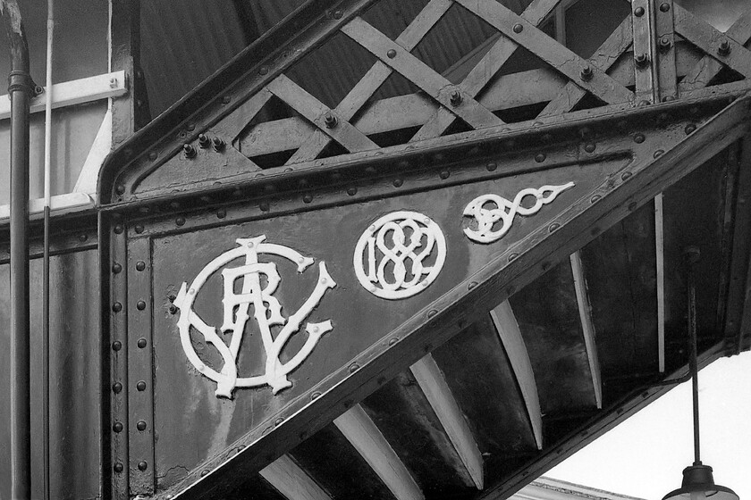 Ex GWR roundel, footbridge, St. Austell station 
 Many railway companies were very keen to remind their customers of their identity and made somewhat extravagant statements that would have been costly at the time of construction. A good example is seen at St. Austell station. As well as being constructed out of both wrought and cast iron the footbridge is festooned with some delightful details such as the early example of a GWR roundel and a date indicating construction in 1882. 
 Keywords: Ex GWR roundel footbridge St. Austell station