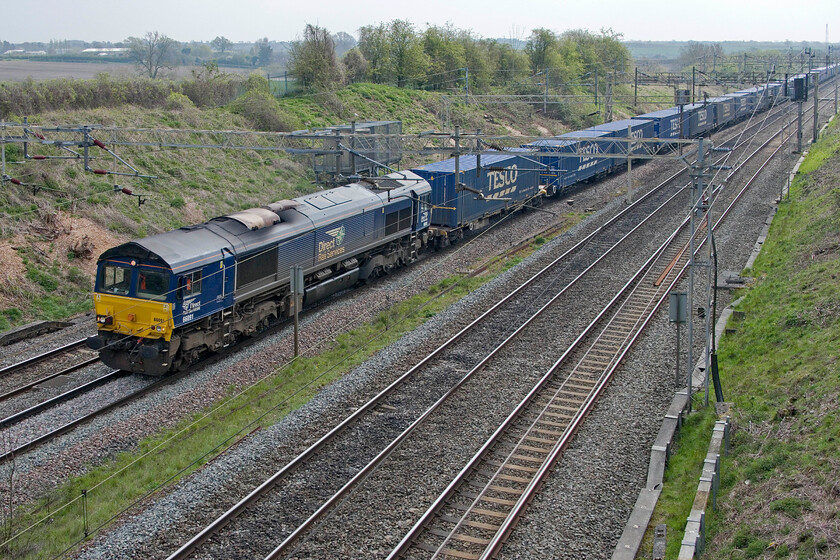 66091, 08.02 Tilbury-DIRFT (4M07, RT), Victoria bridge 
 After standing on Victoria bridge south of Roade in some pleasant sunshine as the trains approached, off course, it dived behind some cloud! DRS 66091 leads the 08.02 Tilbury to Daventry (DIRFT) Tesco Express. The last time that I photographed this particular Class 66 conditions were a little different and it also carried a different livery, see. https://www.ontheupfast.com/p/21936chg/23791615604/x66091whitley-bridge-station 
 Keywords: 66091 08.02 Tilbury-DIRFT 4M07 Victoria bridge Tesco Express DRS