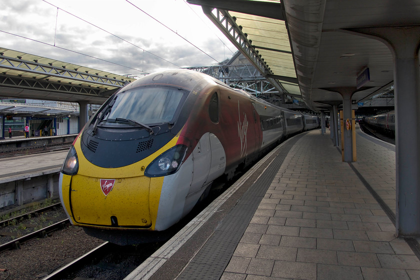 390020, VT 19.35 Manchester Piccadilly-London Euston (1A68, 3E), Manchester Piccadilly station 
 Having arrived at Manchester Piccadilly on-time from Carlisle we had a comfortable connection for our second train home to Milton Keynes. 390020 waits to leave with the 19.35 to London Euston. Whilst the journey was comfortable enough and ran to time, the interiors of the Pendolino was looking a little tired. With a new operator about to take over these iconic trains on this route, let's hope that they embark on a refurbishment programme. 
 Keywords: 390020 19.35 Manchester Piccadilly-London Euston 1A68 Manchester Piccadilly station