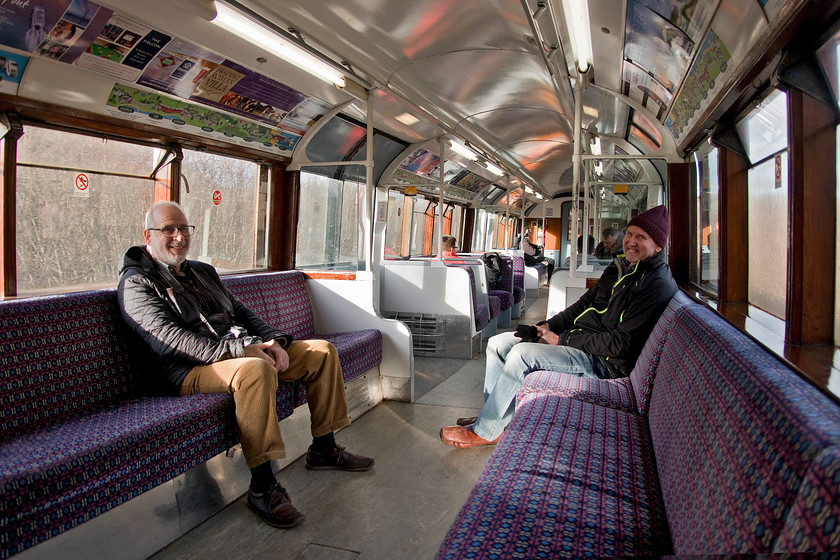 Mike & Andy on-board 483008, SW 12.07 Ryde Pier Head-Shanklin (2D27) 
 Taking a photograph or, for that matter, taking a cup of coffee on-board one of The Island Line services is a challenge. They travel a maximum of forty-five miles an hour but it feels so much quicker due to the crazy ride! The trains buck around and clatter on the bull head rail that has seen better days. We were not sure if it was more the condition of the track or the eighty year old units that created this disconcerting ride. It will be extremely interesting when the Vivarail Class 484s arrive very soon if the ride will improve or if the track will need replacement too? Andy and Mike appreciate the soft seats on 483009 as it rattles its way between Ryde and Brading. 
 Keywords: Mike Andy on-board 483008 12.07 Ryde Pier Head-Shanklin 2D27 Island Line SWT 1938 London Underground stock