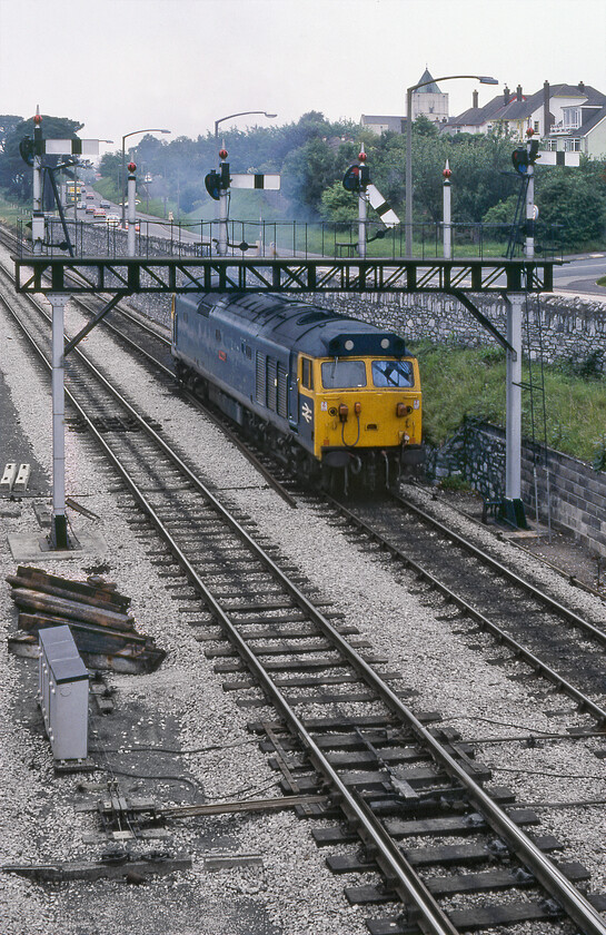 50045, light engine to Laira, Aller Junction 
 50045 'Achillies' is pegged to head off up and over the Devon banks (the first being Dainton a short distance away from here at Aller Junction). It will have an easy time of it running as an unidentified light engine movent to Plymouth Laira. Despite all the room in the world I have not managed to frame this photograph quite correctly, no luxuries then of high-speed continuous shooting with just one chance to expose a single Kodachrome slide on my superb Pentax ME Super! 
 Keywords: 50045 light engine to Laira Aller Junction Achillies