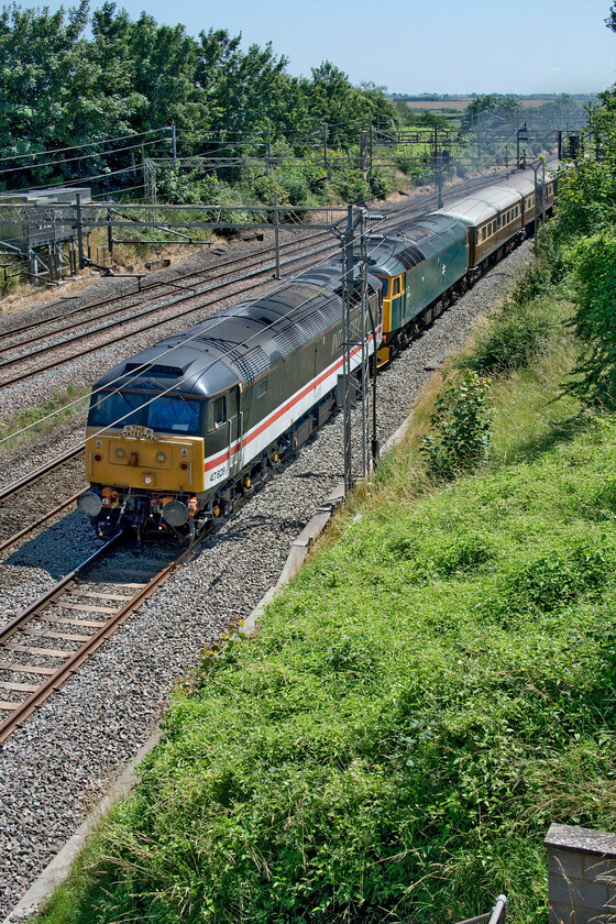 47828 & 47614, 12.22 Willesden Yard-Crewe HS ECS (5Z72, 20E), Victoria bridge 
 A train that caught me out on two counts! I had spotted this 5Z92 12.22 Willesden Yard to Crewe (LSL) empty coach stock working on my daily preview of 'trains of interest' passing near to my home but half expected it not to run. However, it soon became clear that it was all 'go-go-go' (with apologies to the late Murray Walker as this was the day of the British GP) so I downed tools at home and set out for a hot walk to Victoria bridge just south of Roade. I was not expecting the train to be double-headed with both 47828 and 47614 under power and had not anticipated the train being put on the fast line at Hanslope Junction. I did feel a little sorry for any fellow enthusiasts who had gone out to see the train on the Northampton loop only to see it on their mobile phones heading away past Weedon! 
 Keywords: 47828 47614, 12.22 Willesden Yard-Crewe HS ECS 5Z72 Victoria bridge LSL Locomotive Services Ltd