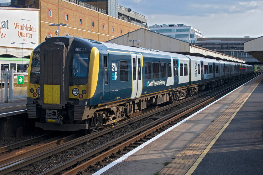 450113 & 450034, SW 17.37 London Waterloo-Alton (2L55, RT), Wimbledon station 
 During my brief stay at Wimbledon of about thirty minutes this was the only train that I observed actually stopping at one of the 'fast' platforms necessitating staff opening the sliding gates to permit entry and exit from the train. 450113 and 450034 have just come to halt at platform seven working SWR's 17.37 Waterloo to Alton service. 
 Keywords: 450113 450034 17.37 London Waterloo-Alton 2L55 Wimbledon station SWR South Western Railway