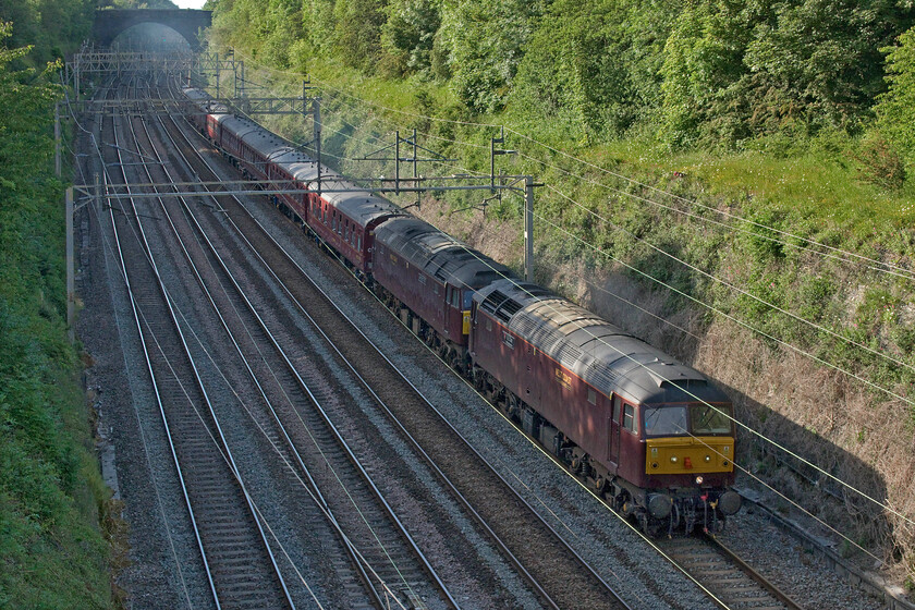 47254 & 47772, 11.23 Carnforth-Southall WCR (5V42, 23E), Roade Hyde Road bridge 
 I was really pleased to see that the 11.23 Carnforth to Southall WCR's empty stock move was double-headed rather than in top and tail mode as it appeared around the curve in the distance in Roade cutting. However, it did require a quick adjustment to the focal length of the lens as I had set it up to fit a single locomotive in the space between the bridge I'm standing on and the first electrification mast. 47254 and 47772 just miss the afternoon sun with it not quite reaching the depths of the cutting this late in the day but it does reveal the significant levels of exhaust behind the train! 
 Keywords: 47254 47772 11.23 Carnforth-Southall WCR 5V42 Roade Hyde Road bridge WCR West Coast Railways