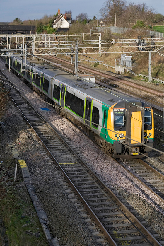 350104, LM 10.02 Crewe-London Euston (1U26), site of Roade station 
 350104 bursts into the winter sunshine at Roade forming the 10.02 Crewe to Euston London Midland service. It is not particularly common to have a 350/1 subset on these 'fast' services with the company preferring to use the 350/3 subset that is capable of a slightly higher maximum speed of one hundred and ten miles per hour. 
 Keywords: 350104 10.02 Crewe-London Euston 1U26 site of Roade station London Midland Desiro