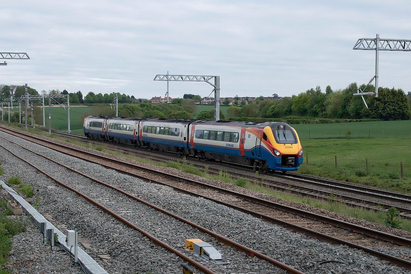 222102, EM 18.05 London St. Pancras-Lincoln Central (1D62, 8L), Irchester SP927667 
 With the Northamptonshire village of Irchester in the background, 222102 is at full line speed in the descent from Sharnbrook summit with the 18.05 St. Pancras to Lincoln. Whilst the railways persist in referring to Lincoln station as 'Central' I do not as it seems somewhat silly as there is only one station in the town and it has been this way since St. Marks closed in thirty-four years ago! In this photograph, note the reinstated up and down relief lines that have been laid. Of the two, only the right-hand track is in use as the left (to be the up slow) is not yet connected ending abruptly just behind me in a sea of ballast. 
 Keywords: 222102 18.05 London St. Pancras-Lincoln Central 1D62 Irchester SP927667