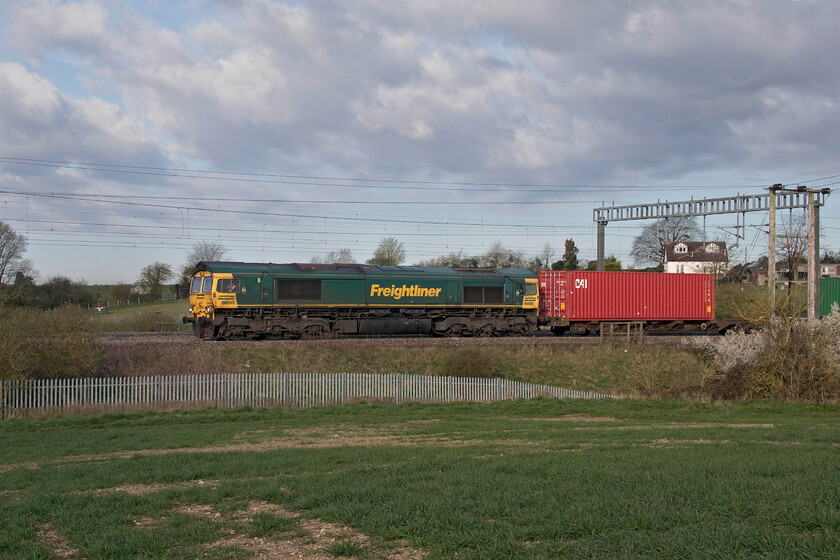 66545, 03.39 Garston-London Gateway (4L52, 6E), between Roade & Ashton 
 After standing in full sun for the last ten minutes or so as the 4L52 03.39 Garston to London gateway approached cloud partially covered it! 66545 leads the train through the Northamptonshire countryside between Roade and Ashton. 
 Keywords: 66545 03.39 Garston-London Gateway 4L52 between Roade & Ashton Freightliner