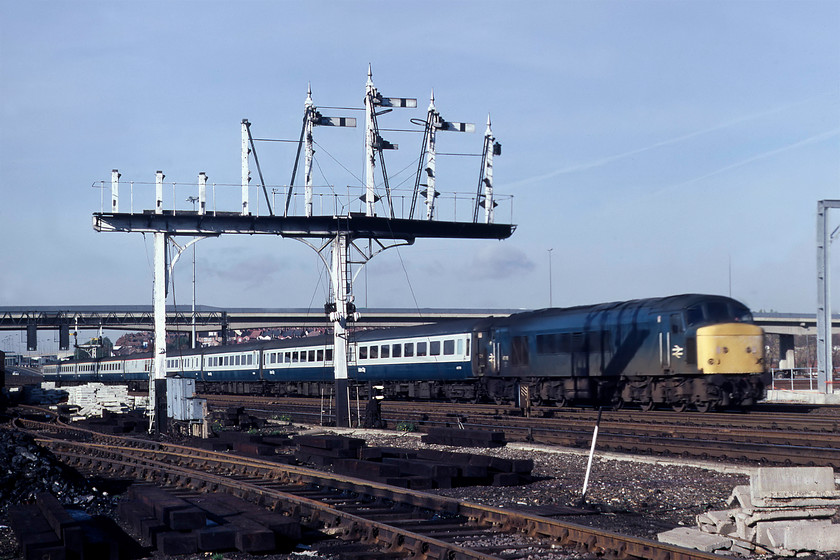 45116, 08.04 Leeds-London St. Pancras (1M14), Brent yard TQ231867 
 This magnificent Midland signal gantry should have been saved from demolition and preserved, unfortunately, it was not! It once carried signals on all of its eight dolls but many have been removed. I have found a contemporary photograph of the gantry looking from the north with all of the small arms still in place controlling entry to the yard roads. The fact that all but one has been removed indicates the general rationalisation and re-signaling that was taking place at this time. 45116 is passing the gantry, still at a fair rate of knots as it approaches its destination, St. Pancras, with the 1M14 08.04 from Leeds. 
 Keywords: 45116 08.04 Leeds-London St. Pancras Brent yard TQ231867