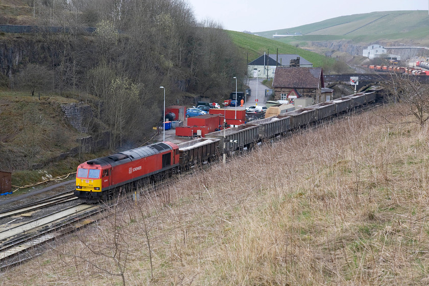 60044, 09.57 Bletchley-Peak Forest, Peak-Forest South 
 The driver in the cab of 60044 peers along the train as it is dragged by the out of sight 66145 slowly into the exchange sidings seen beyond the bridge in the background. The former Peak Forest station building is clearly seen behind the train. Now used by DB Schenker as a signing on point and mess room it was closed to passengers when the Midland through route to Manchester was shut in March 1967. 
 Keywords: 60044 09.57 Bletchley-Peak-Forest, Peak Forest South