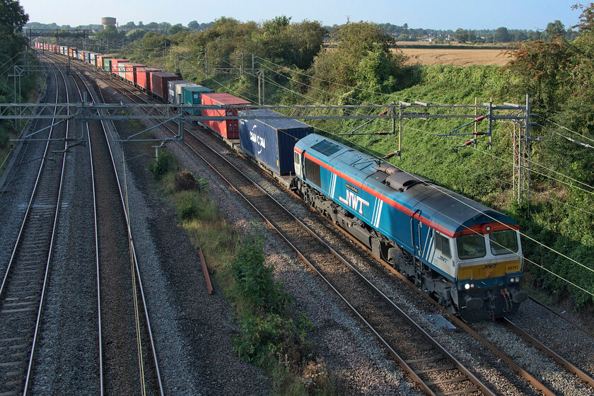 66747, 13.54 Birch Coppice-London Gateway (4L68, 1E), Victoria bridge 
 A photographic cop in the lovely late afternoon sun at Victoria bridge just south of Roade (Northamptonshire). 66747 'Made in Sheffield' arrived in the UK following its use on the continent wearing its plain grey livery back in 2012. It was rapidly repainted into GBRf's paint scheme but I never managed a photograph of it during that time. In the summer of 2019, it was selected to be repainted again this time to promote the growing relationship between GBRf and the logistics company Newell & Wright based in Sheffield with it being named the same a month earlier. It is seen here working the 4L68 13.54 Birch Coppice to London Gateway. 
 Keywords: 66747 13.54 Birch Coppice-London Gateway 4L68 Victoria bridge Made in Sheffield