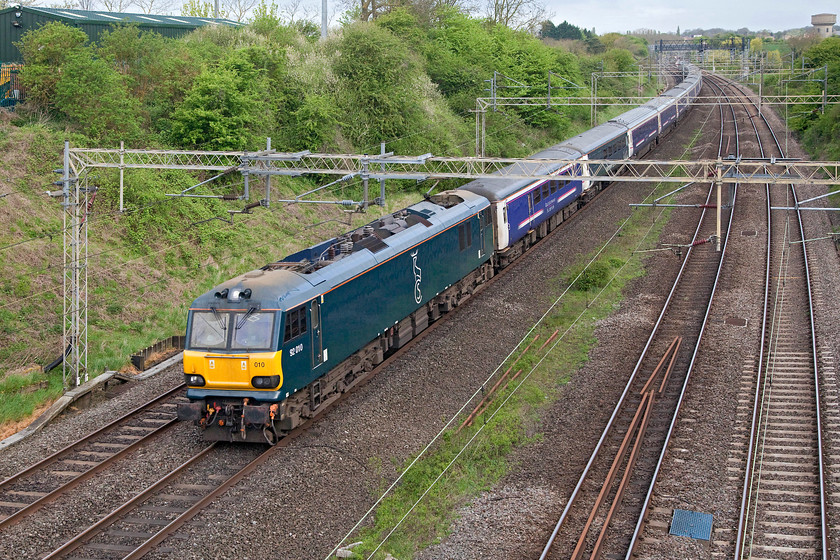 92010, CS 20.44 Inverness 19.50 Fort William 21.43 Aberdeen-London Euston sleeper (1M16, 19L), Victoria Bridge 
 The sleeper was running a bit late that helped with the photo as the light had begun to improve a little. Here, 92010 in its Caledonian Sleeper livery passes Roade on the up fast with about sixty miles to go in order to complete its journey from Scotland, one it started eleven hours previously! 
 Keywords: 92010 20.44 Inverness 19.50 Fort William 21.43 Aberdeen-London Euston sleeper 1M16 Victoria Bridge