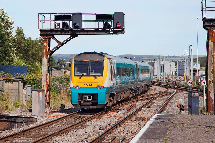 175103, AW 11.10 Milford Haven-Manchester Piccadilly (1W16), Swansea station 
 175103 leaves Swansea under some of its early electrical signalling equipment that was installed in the late 1960s. Now over 40 years old, the salty sea air at Swansea has begun to take its toll on the steelwork. In the background notice the new order in the form of the electrification masts and the construction of the new maintenance and stabling facilities for the IET class 800s. These will be running from here some time soon, however, when I do not know as the programme is now hopelessly behind schedule and way over budget. 
 Keywords: 175103 11.10 Milford Haven-Manchester Piccadilly 1W16 Swansea station