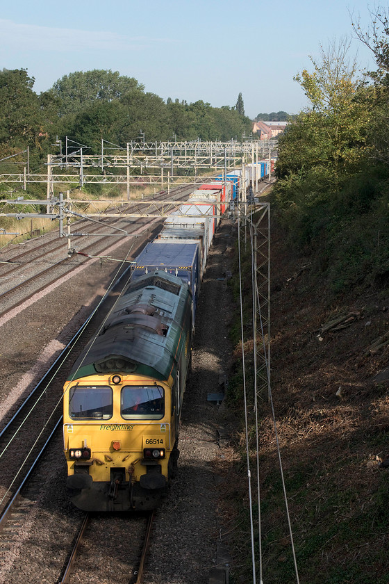 66514, 04.57 Trafford Park-Felixstowe North (4L97), Ashton Road bridge 
 After seeing the Palatine railtour pass a quick look at OpenTrainTimes on my 'phone revealed that the Saturday morning 4L97 was approaching Roade from the north. Stuck for a suitable spot I was pleased to see that Network Rail had been undertaking some tree clearance just north of the Ashton Road bridge south of Roade. This clearance enabled the sun to get on the front of the train, even this early in the morning, meaning a reasonable photograph could be taken. 
 Keywords: 66514 04.57 Trafford Park-Felixstowe North 4L97 Ashton Road bridge