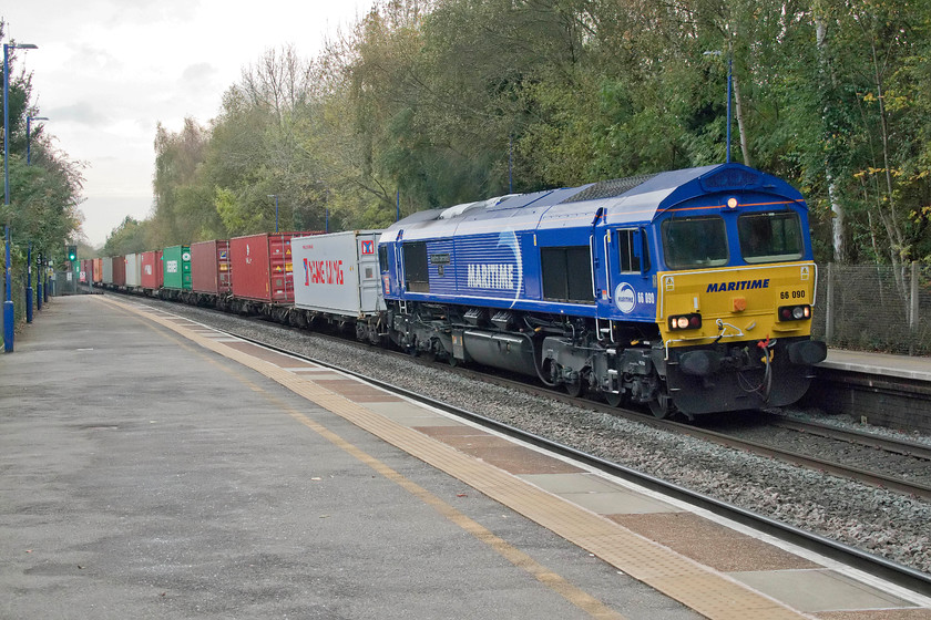 66090, 09.47 Southampton Western Docks-Birch Coppice (4M71), Lapworth station 
 Striking quite a pose as it passes Lapworth station is 66090 'Maritime Intermodal Six' leading the 09.47 Southampton Western Docks to Birch Coppice Freightliner. In this view, it looks as though I need to straighten the photograph up in Photoshop but, as can be seen, it is level against the datum points of the lamp and fence posts. This illustrates the camber that the track is at through Lapworth station, a delightfully quiet spot between Dorridge and Hatton. 
 Keywords: 66090 09.47 Southampton Western Docks-Birch Coppice 4M71 Lapworth station