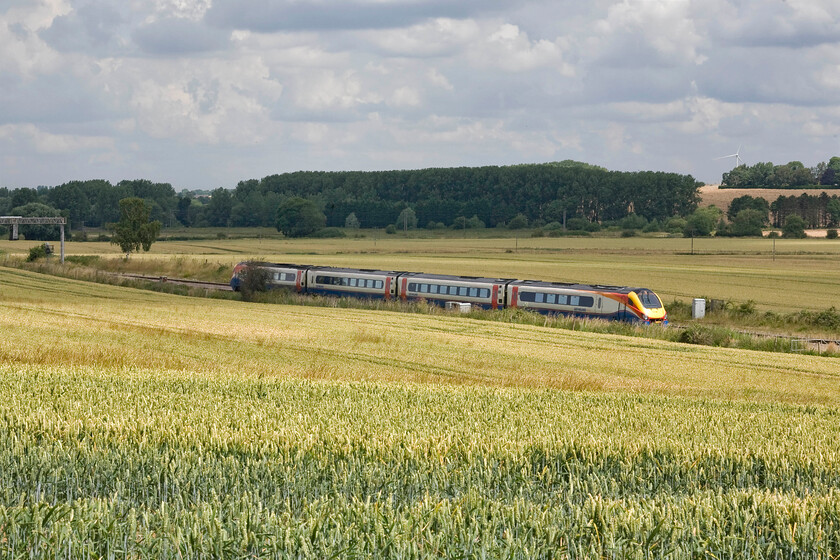 Class 222, EM 11.26 London St. Pancras-Sheffield (1F28), Harowden Junction from The Slips 
 The 11.26 St. Pancras to Sheffield East Midlands Trains service heads north past Harrowden Junction almost camouflaged by the ripening wheat in the foreground. Unfortunately, I have been unable to identify this particular Meridian despite enlarging the number on the nose cone. 
 Keywords: Class 222 11.26 London St. Pancras-Sheffield 1F28 Harowden Junction East Midlands Trains Meridian