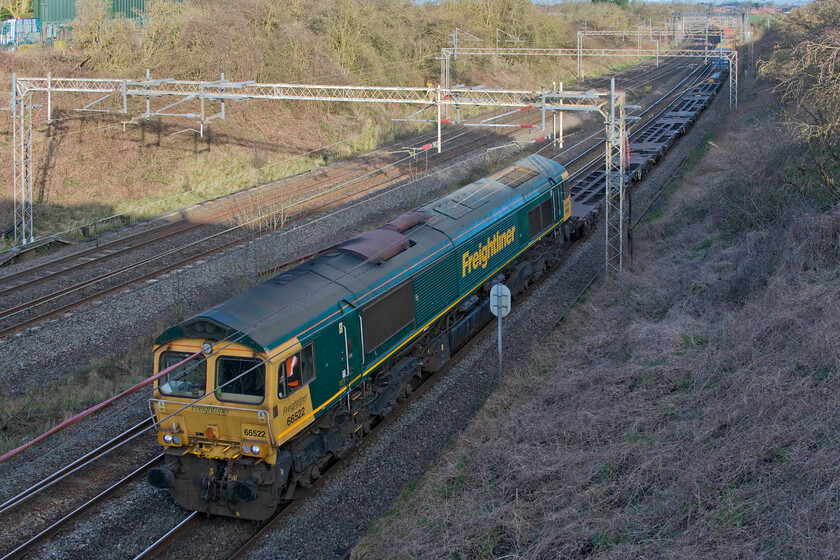 66522, 03.14 Garston-London Gateway (4L52, 9E), Victoria bridge 
 Just too early in the morning for the sun to illuminate the cutting at Victoria bridge near the Northamptonshire village of Ashton. Fortunately, with a camera that can handle extreme contrast and using Photoshop to help things further, a reasonable photograph can be presented. 66522 leads the 4L52 03.14 Garston to London Gateway Freightliner service. 
 Keywords: 66522 03.14 Garston-London Gateway 4L52 Victoria bridge Freightliner