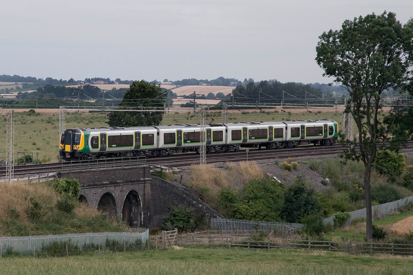 350259, LM 07.46 London Euston-Crewe (1U25, 3L), Castlethorpe SP795447 
 350259 works north on the down fast line crossing Three Arches bridge just north of the village of Castelthorpe between Milton Keynes and Northampton. It is working the 07.46 Euston to Crewe 'fast' service. I say 'fast' as it is as far as Colwich Junction (Staffordshire) from where it becomes a winding and slow stopper to Crewe following a circuitous route. 
 Keywords: 350259 1U25 Castlethorpe SP795447