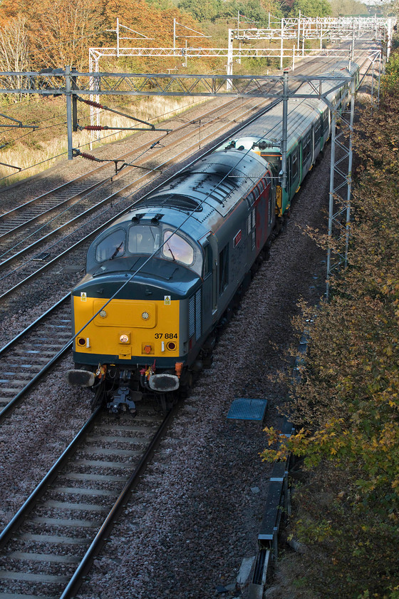 37884 & 455819, 08.55 Wolverton Centre Sidings-Stewarts Lane (5Q88), Dansteed Way bridge 
 The regular Saturday morning 5Q88 move is the 08.55 Wolverton Works to Stewart's Lane. This move involves the towing of a class 455 having received repairs at Wolverton. Another Southern electric is then towed back later in the day. Taken from Dansteed Way in Milton Keynes, 37884 'Cepheus' leads 455819. Unfortunately, opportunities to photograph in this area are extremely limited, if it had been an hour later it would have been in the sun! 
 Keywords: 37884 455819 08.55 Wolverton Centre Sidings-Stewarts Lane 5Q88 Dansteed Way bridge