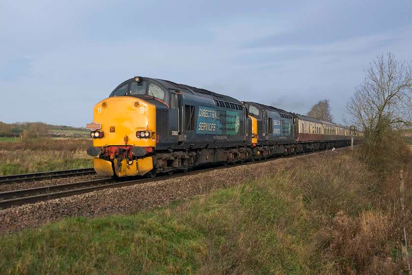 37602 & 37605, outward leg of The Jolly Marketeer, 06.18 Derby-Chichester (1Z47), King's Sutton 
 37602 and 37605 shatter the peace as they pass King's Sutton on a late November morning. Despite that, the sky had clouded over some weak sunshine has just managed to catch the front of the train that makes a pleasant change from what usually happens! The Pathfinder charter, running as 1Z47, left Derby at 06.18 and was heading to Chichester giving travellers the opportunity to sample the Anglo-Saxon city's famous Christmas market.

There is an audio recording of this event on my youtube channel, see.... https://youtu.be/_5wqxUjKE-s 
 Keywords: 37602 37605 outward leg of The Jolly Marketeer, 06.18 Derby-Chichester 1Z47 King's Sutton DRS Pathfinder Tours