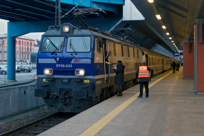 EP09-025, 13.35 Przemyssl Glwny-Wroclaw Glwny (IC3600), Krakw Glwny station 
 The driver of EP09-025 leans down to collect information from his guard whilst a dispatcher looks on ready to get the 13.35 Przemyssl Glwny to Wroclaw Glwny underway from Krakw. Przemyssl is a town on the far eastern Polish border with Ukraine with this train going all the way to the capital. It has a travelling distance of six hundred and sixty kilometres (four hundred and ten miles). 
 Keywords: EP09-025 13.35 Przemyssl Glwny-Wroclaw Glwny IC3600 Krakw Glwny station PKP