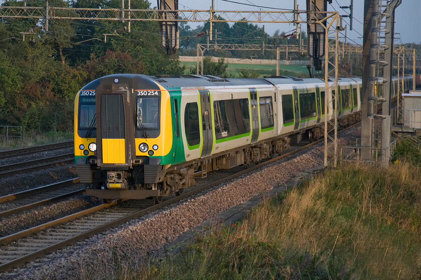 350254, LM 07.00 Northampton-London Euston (1N82), Roade Hill 
 Catching some welcome early morning light 350254 and two other units pass Roade Hill working the 07.00 Northampton to Euston commuter service. Despite the shortening days and the inevitable crash towards winter, I love the lighting at this time of year particularly in the early morning making the effort to get up at get out! 
 Keywords: 350254 07.00 Northampton-London Euston 1N82 Roade Hill London Midland Desiro