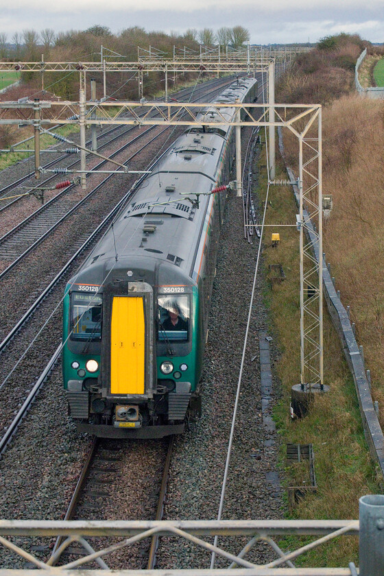 350128, LN 07.06 Birmingham New Street-London Euston (1Y10, 2L), Castlethorpe SP790453 
 350128 passes south working the 1Y10 07.06 Birmingham New Street to Euston service. It is passing a remote occupation bridge north of Castlethorpe access to which required a long walk in one direction on tracks or a very muddy shorter field walk in the other. Given the recent very wet weather, I chose the former longer route! 
 Keywords: 350128 07.06 Birmingham New Street-London Euston 1Y10 Castlethorpe SP790453 London Northwestern Desiro